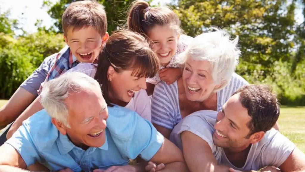 Multi Generation Family Piled Up In Garden Together and money savers