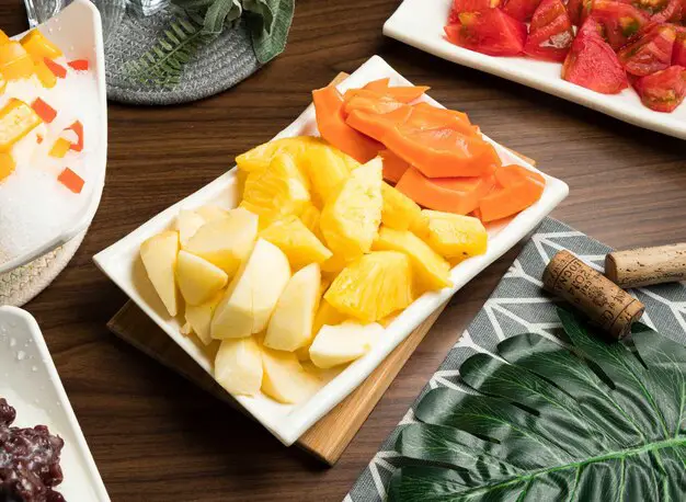 assorted-seasonal-veggies and fruit-mango-banana-apple-pineapple-served-bowl-isolated-table-side-view-taiwan-food_